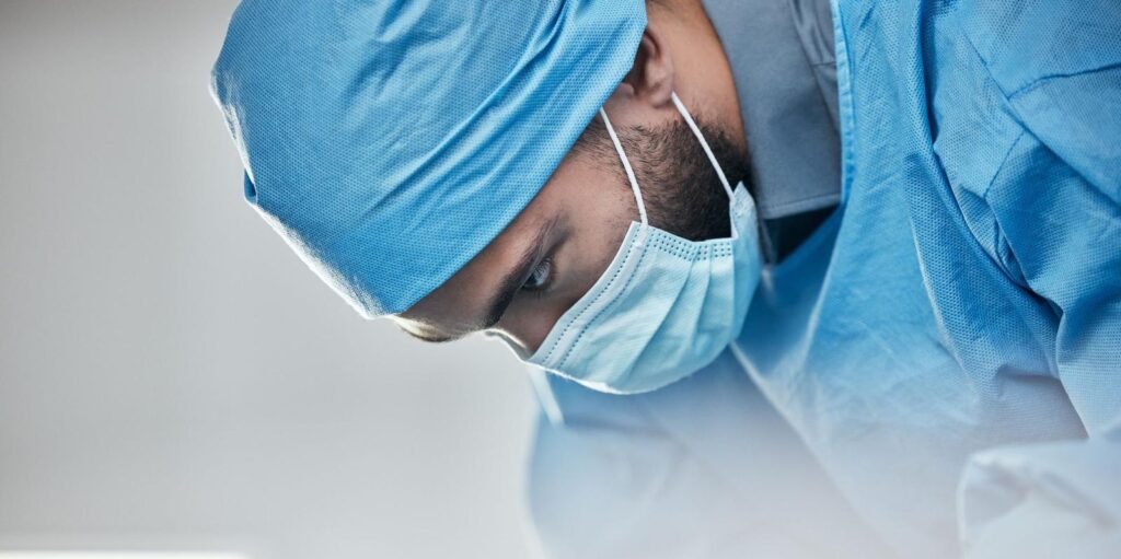 Doctor in a surgical cap and mask during a procedure – Mae Academy